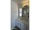 Bathroom with linoleum flooring, a window, and a white vanity with a sink and mirror at 8730 E Dolega Ave, Mesa, AZ 85208