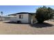 This home features desert landscaping, an AC unit and an attached storage shed for convenience at 8730 E Dolega Ave, Mesa, AZ 85208