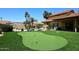 Well-manicured putting green in the backyard with a swimming pool and patio area at 17408 N 57Th St, Scottsdale, AZ 85254