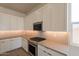 Modern kitchen with white cabinets, gas range, and herringbone backsplash at 17990 W Long Lake Rd, Goodyear, AZ 85338