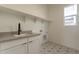 Laundry room with farmhouse sink and star patterned floor at 17990 W Long Lake Rd, Goodyear, AZ 85338