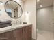 A stylish vanity with a round mirror and a fully equipped walk-in shower give this bathroom a modern look at 3955 E Sierra Vista Dr, Paradise Valley, AZ 85253