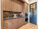A wood paneled butlers pantry with upper and lower cabinets features a built in oven and a stone countertop at 3955 E Sierra Vista Dr, Paradise Valley, AZ 85253