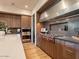 A modern kitchen with light stone countertops, stainless steel appliances and an elegant faucet and range hood at 3955 E Sierra Vista Dr, Paradise Valley, AZ 85253
