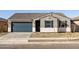 Single-story house featuring a gray exterior, dark garage door, and landscaping at 25218 N 160Th Dr, Surprise, AZ 85387