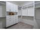 Spacious walk-in closet with white shelving, drawers, and wood floor, ready to be organized at 37200 N Cave Creek Rd # 2110, Scottsdale, AZ 85262
