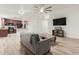 Open living space with gray sofa, wood-look tile floors and kitchen view at 3932 N Silver King Ln, Casa Grande, AZ 85122