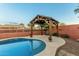 Refreshing kidney-shaped pool with a charming pergola and surrounding landscaping at 3932 N Silver King Ln, Casa Grande, AZ 85122