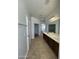 Double vanity bathroom with tile floors and access to a walk-in closet at 12827 S Hermit Rd, Buckeye, AZ 85326