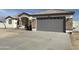 White single story home with gray garage door and stone accents at 12827 S Hermit Rd, Buckeye, AZ 85326
