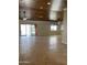 Large living room with tile flooring, wood-paneled ceiling, and access to patio at 12827 S Hermit Rd, Buckeye, AZ 85326