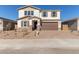 Two-story home with stone accents and brown garage door at 5018 W Top Hand Trl, Laveen, AZ 85339