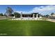 A modern home's backyard with expansive lawn, and a pool under construction at 12232 N 65Th Pl, Scottsdale, AZ 85254