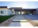 Contemporary home with stone accents and manicured landscaping leading to a glass front door at 12232 N 65Th Pl, Scottsdale, AZ 85254