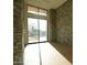 Hallway featuring stone walls, light hardwood floors, and a large glass window at 12232 N 65Th Pl, Scottsdale, AZ 85254