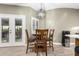 Cozy dining area with a wooden table, four chairs, modern light fixture, and access to the patio at 38334 N 20Th St, Phoenix, AZ 85086