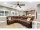 Spacious living room featuring a comfortable brown sectional sofa and ceiling fan at 38334 N 20Th St, Phoenix, AZ 85086