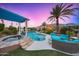 Stunning pool, spa, & outdoor seating area with pergola under a beautiful sunset at 10417 N 180Th Dr, Waddell, AZ 85355