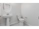Stylish powder room featuring modern fixtures, pedestal sink, and a white toilet at 19655 E Estrella Rd, Queen Creek, AZ 85142