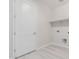 Well-lit laundry room with tile floors, open shelving, and connections for a washer and dryer at 19655 E Estrella Rd, Queen Creek, AZ 85142