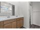 Bathroom featuring a double sink vanity with wood cabinets and a shower with a glass door at 5729 S 243Rd Dr, Buckeye, AZ 85326