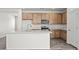 Bright kitchen featuring an island with a sink, stainless steel appliances, and wooden cabinets at 5729 S 243Rd Dr, Buckeye, AZ 85326