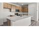 Modern kitchen featuring an island with seating, stainless steel appliances, and wooden cabinets at 5729 S 243Rd Dr, Buckeye, AZ 85326