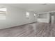 Spacious living room featuring wood-look floors and lots of natural light from multiple windows at 5729 S 243Rd Dr, Buckeye, AZ 85326