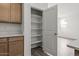 View of a pantry with shelving, accessible from a kitchen with wooden cabinets at 5729 S 243Rd Dr, Buckeye, AZ 85326