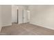 Neutral carpeted bedroom featuring open doorway and two interior doors at 19679 E Estrella Rd, Queen Creek, AZ 85142