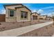 Charming single-story home with stone accents and a well-maintained front yard featuring desert landscaping at 19679 E Estrella Rd, Queen Creek, AZ 85142