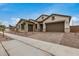 Charming home showcasing a tandem three-car garage, stone accents, and a well-manicured yard at 19679 E Estrella Rd, Queen Creek, AZ 85142