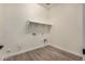 Functional laundry room with a shelf and tile flooring, ready for appliances and storage at 19679 E Estrella Rd, Queen Creek, AZ 85142
