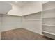 Walk-in closet with neutral carpeting, white walls, and built-in shelving at 19679 E Estrella Rd, Queen Creek, AZ 85142