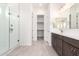 Bright bathroom with glass shower, dual-sink vanity and large walk-in closet at 17225 W Calle Lejos --, Surprise, AZ 85387