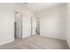 Open bedroom with plush neutral carpeting, white walls, and views into hallway and closet at 17225 W Calle Lejos --, Surprise, AZ 85387