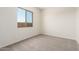 Sunlit bedroom with carpeted floors, white walls, and a window with neighborhood views at 17225 W Calle Lejos --, Surprise, AZ 85387