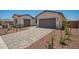 Paver driveway leading to two-car garage, complemented by desert landscaping and attractive exterior finishes at 17225 W Calle Lejos --, Surprise, AZ 85387