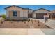 Charming single-story home featuring a stone facade, desert landscaping, a two-car garage, and neutral exterior paint at 17225 W Calle Lejos --, Surprise, AZ 85387