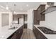 Modern kitchen boasts dark cabinets, white subway tile backsplash, stainless steel appliances, and a large center island at 17225 W Calle Lejos --, Surprise, AZ 85387