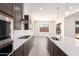 Modern kitchen featuring dark cabinets, white subway tile backsplash, stainless steel appliances, and a breakfast bar at 17225 W Calle Lejos --, Surprise, AZ 85387