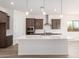 Modern kitchen boasts dark cabinets, white subway tile backsplash, stainless steel appliances, and a large center island at 17225 W Calle Lejos --, Surprise, AZ 85387