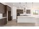 Modern kitchen boasts dark cabinets, white subway tile backsplash, stainless steel appliances, and a large center island at 17225 W Calle Lejos --, Surprise, AZ 85387