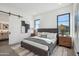 Spacious bedroom with a gray bed, wooden nightstands, and a barn door at 1501 N Miller Rd # 1011, Scottsdale, AZ 85257