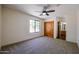 Spacious bedroom with wood doors, ceiling fan, and carpeted floor at 19927 W Meadowbrook Ave, Litchfield Park, AZ 85340