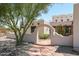 Spanish-style home entry with arched walkway, flagstone path, and mature tree at 19927 W Meadowbrook Ave, Litchfield Park, AZ 85340