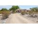 Front view of stucco home with arched entryway and desert landscaping at 19927 W Meadowbrook Ave, Litchfield Park, AZ 85340