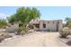 Front view of stucco home with arched entryway and desert landscaping at 19927 W Meadowbrook Ave, Litchfield Park, AZ 85340