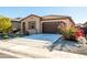 Charming one-story home with red flowers and gravel landscaping at 12179 E Sereno Rd, Gold Canyon, AZ 85118