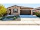 Single-story house with a brown garage door and well-maintained landscaping at 12179 E Sereno Rd, Gold Canyon, AZ 85118